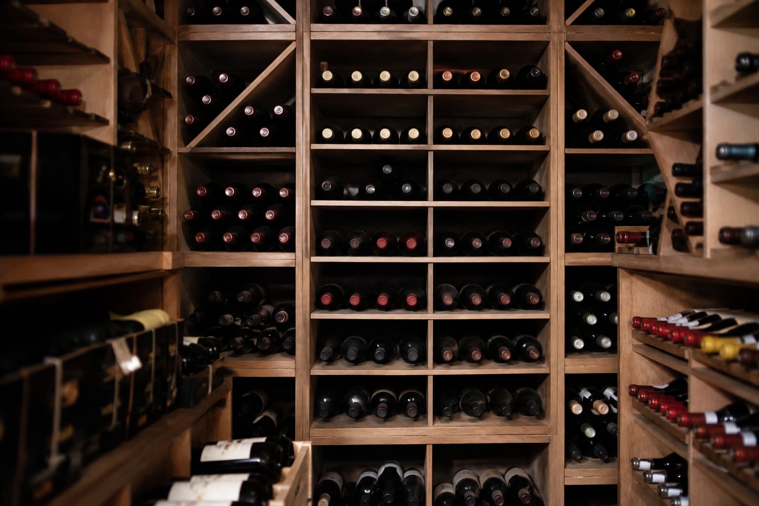 Étagères de cave bien rangées avec des bouteilles étiquetées.